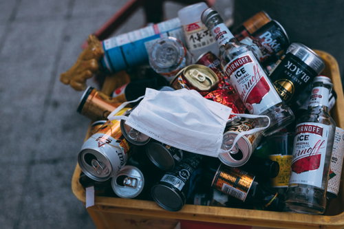 空き缶や空き瓶の中にポイ捨てされた白いマスク