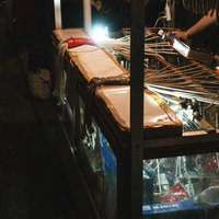 紐のどれかを引っ張ると豪華賞品が当たる露天の千本引きの写真