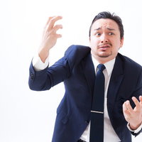 顔が歪むほどの失敗をしたビジネスマンのジェスチャーの写真