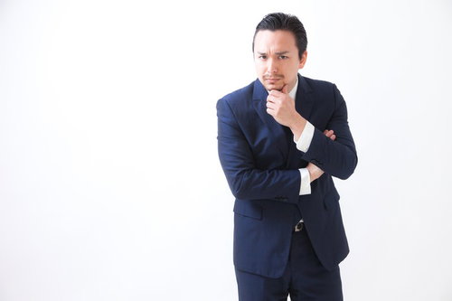 考える表情のビジネスマン、紺色スーツの男性