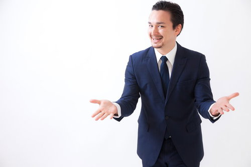 やるなら、今ですよ！と身振りで説得するスーツ姿の男性
