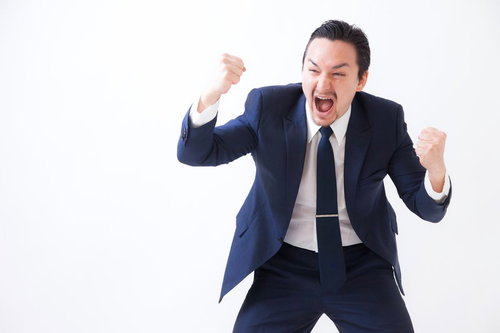 奇声をあげ両拳を握り興奮するスーツ姿の男性