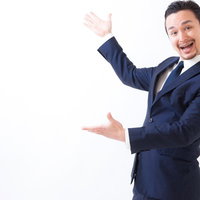 新商品をお披露目する笑顔の男性がジェスチャーで案内の写真