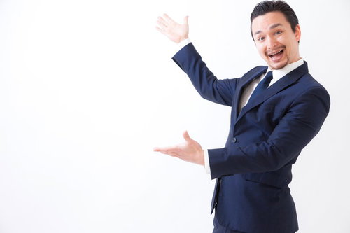 新商品をお披露目する笑顔の男性がジェスチャーで案内