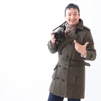 コートを着た外国人観光客がカメラを構えるの写真