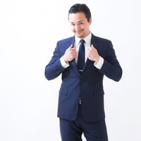 カメラを持って指差しするドイツ人ハーフの男性の写真