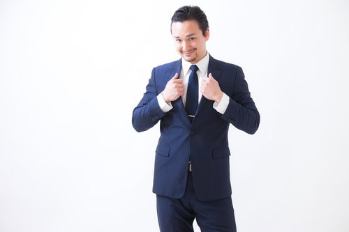 カメラを持って指差しするドイツ人ハーフの男性の写真