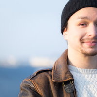 海を背景にした笑顔のドイツ人ハーフ男性のポートレートの写真