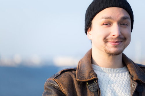 海を背景にした笑顔のドイツ人ハーフ男性のポートレート