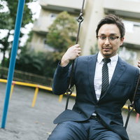 リストラされたことを家族に言えず、公園のブランコで時間を潰すドイツ人ハーフ男性の写真