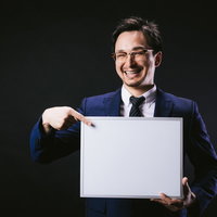 笑顔でフリップの内容を指差して伝えるドイツ人ハーフの男性の写真