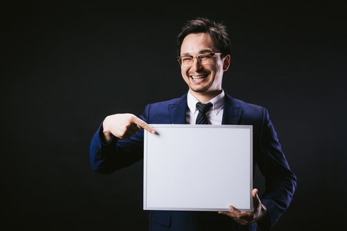 笑顔でフリップの内容を指差して伝えるドイツ人ハーフの男性