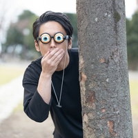 目を丸くして驚く木陰の眼鏡をかけた男性の表情の写真