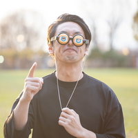 への字口で怒りをあらわにする眼鏡をかけた男性の写真