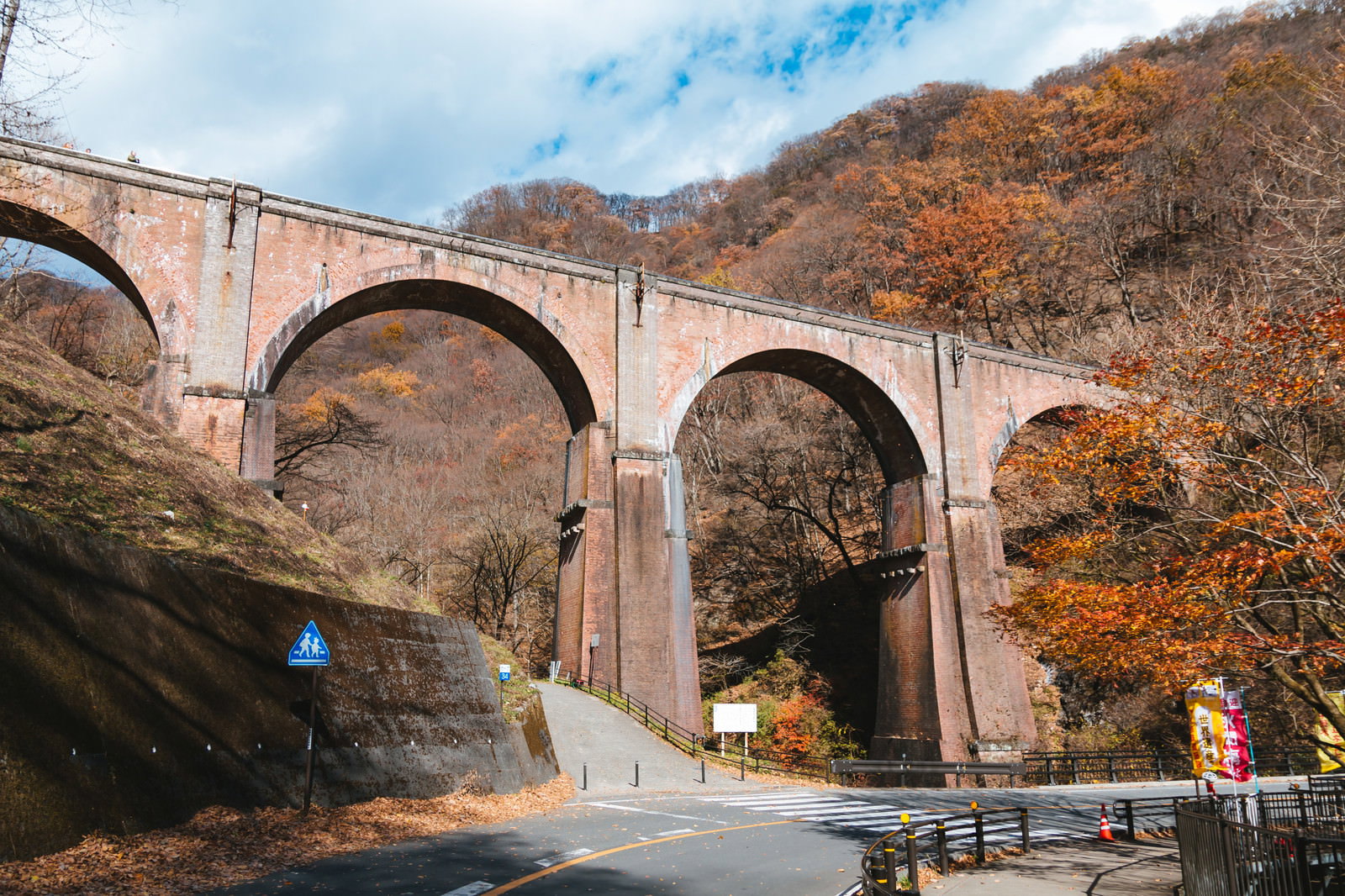 碓氷峠めがね橋と紅葉の山を見上げる