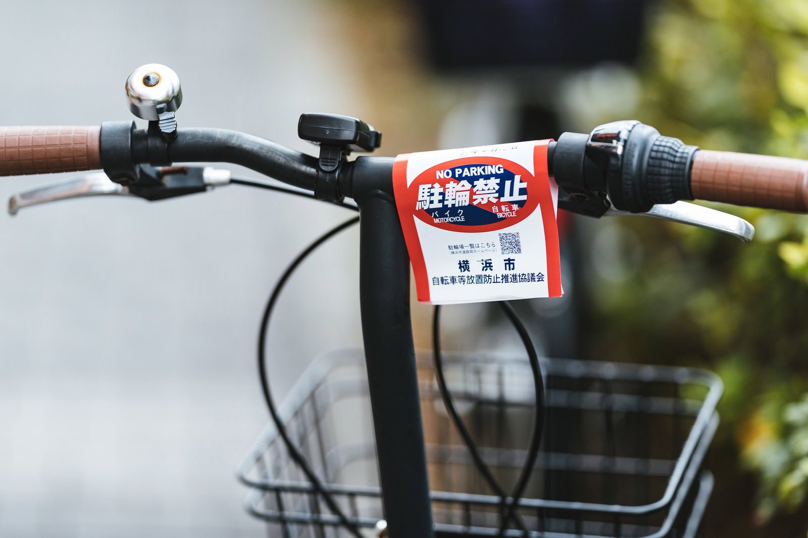 自転車のハンドルに赤い駐輪禁止の警告札が取り付けられている様子