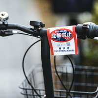 自転車のハンドルに付けられた赤い駐輪禁止の警告書の写真