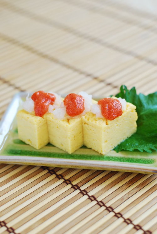 明太子入りの玉子焼き、白い皿に大葉を添えた和食のおかず