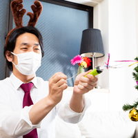 クラッカーを使ってメリクリする孤独な会社役員の写真