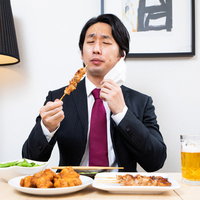 黙食でマスク着用したサラリーマンが焼き鳥と生ビールで忘年会の写真