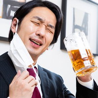 仕事終わりの生ビールをゴクゴク飲んで上機嫌の会社員の写真
