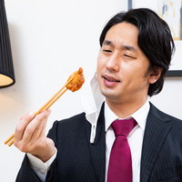 食べるごとにマスクを外す会社員男性の食事風景の写真