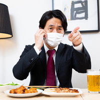 マスク会食中にマスクから鼻が出てると指を差して注意する会社員の写真