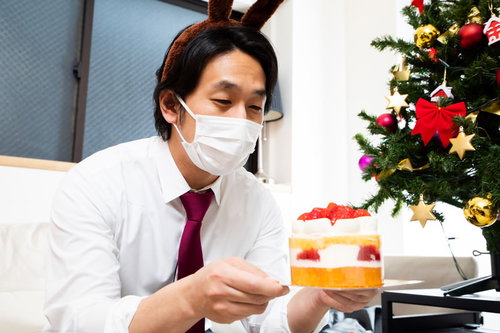 小振りのクリスマスケーキを見つめるクリボッチャー男性