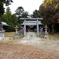 三春大神宮の参道に立つ石造りの鳥居と本殿の写真