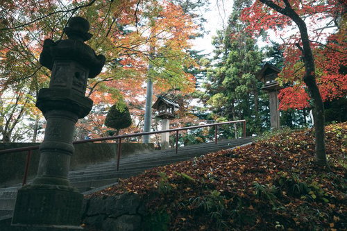 三春町の秋の三春神社参道で紅葉に包まれた石段と灯篭
