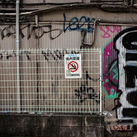 落書きと禁煙標識が語る裏通りの写真