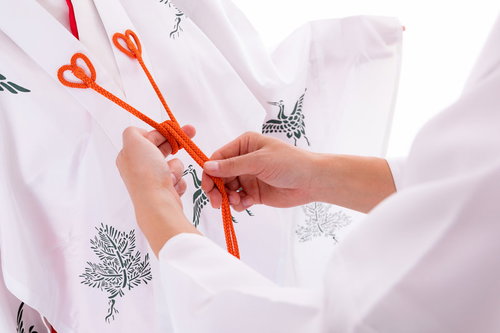千早の赤い紐を結ぶ巫女の手元 白装束での紐結びの作法