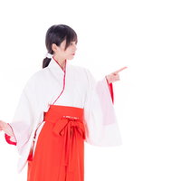 初詣の参拝はあちらですと案内する巫女の写真