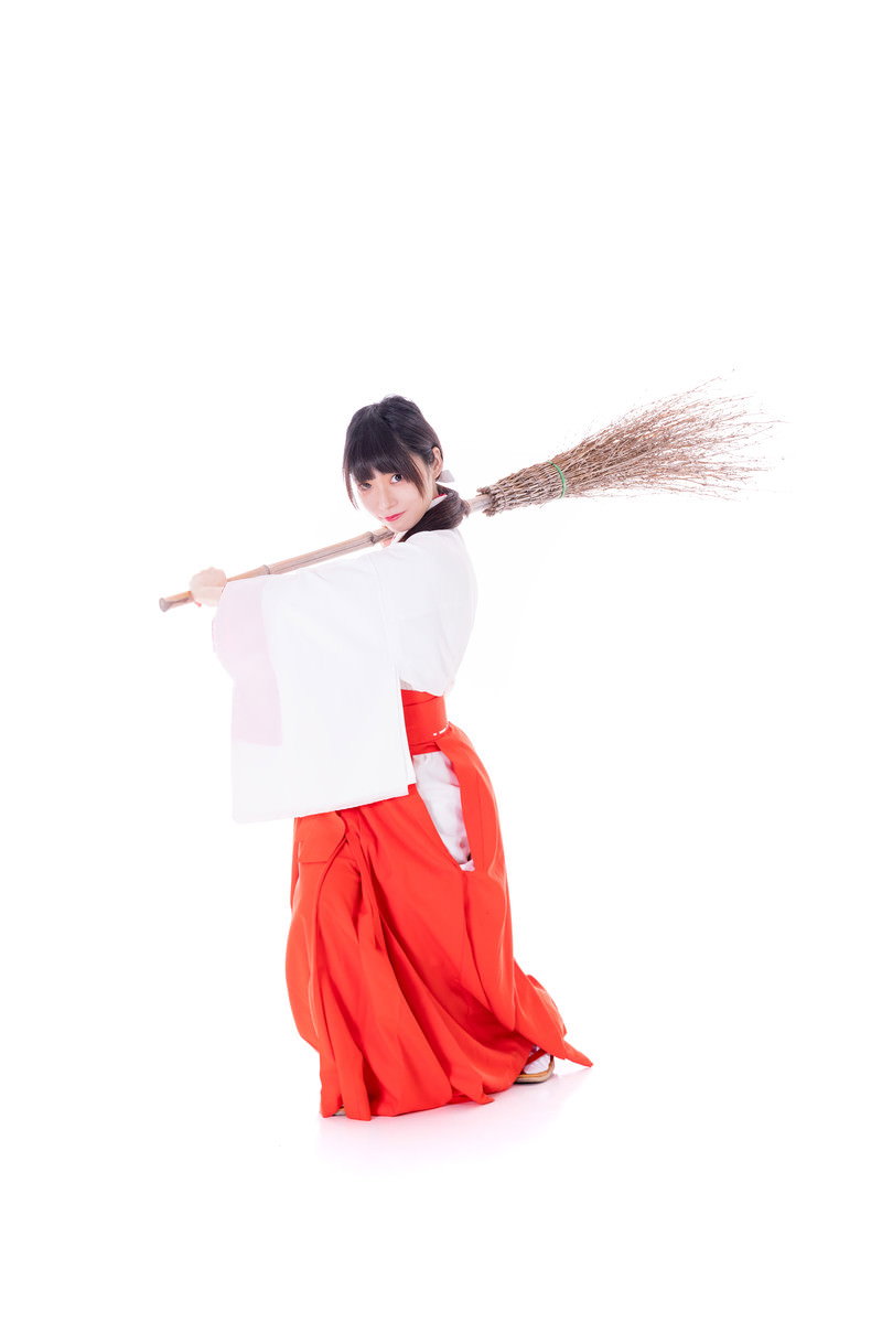 白い装束と赤い袴を着た巫女がバッターポーズをとっている［モデル：緋真煉］