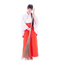 掃除中の巫女さんがお出迎え、竹箒を持ち笑顔で神社参拝者をもてなすの写真