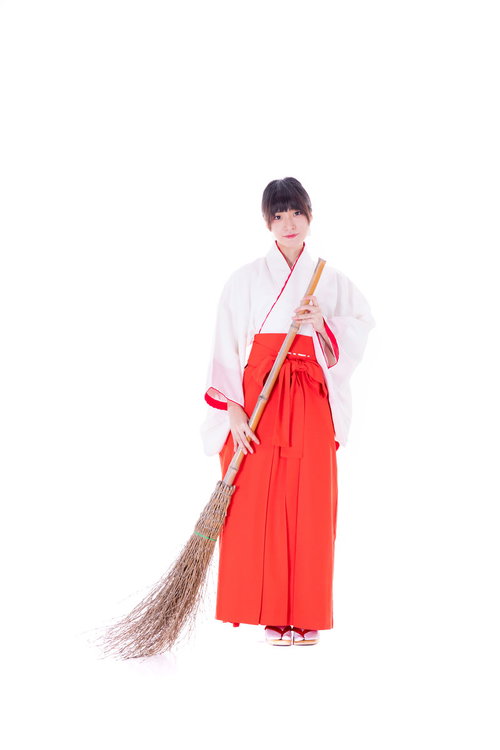 おでかけですか？竹箒を持つ巫女が神社で掃除作業