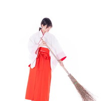 竹箒で隅々まで丁寧に掃く巫女の日常風景の写真