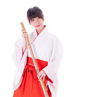 神社で掃き掃除をする巫女さんの写真