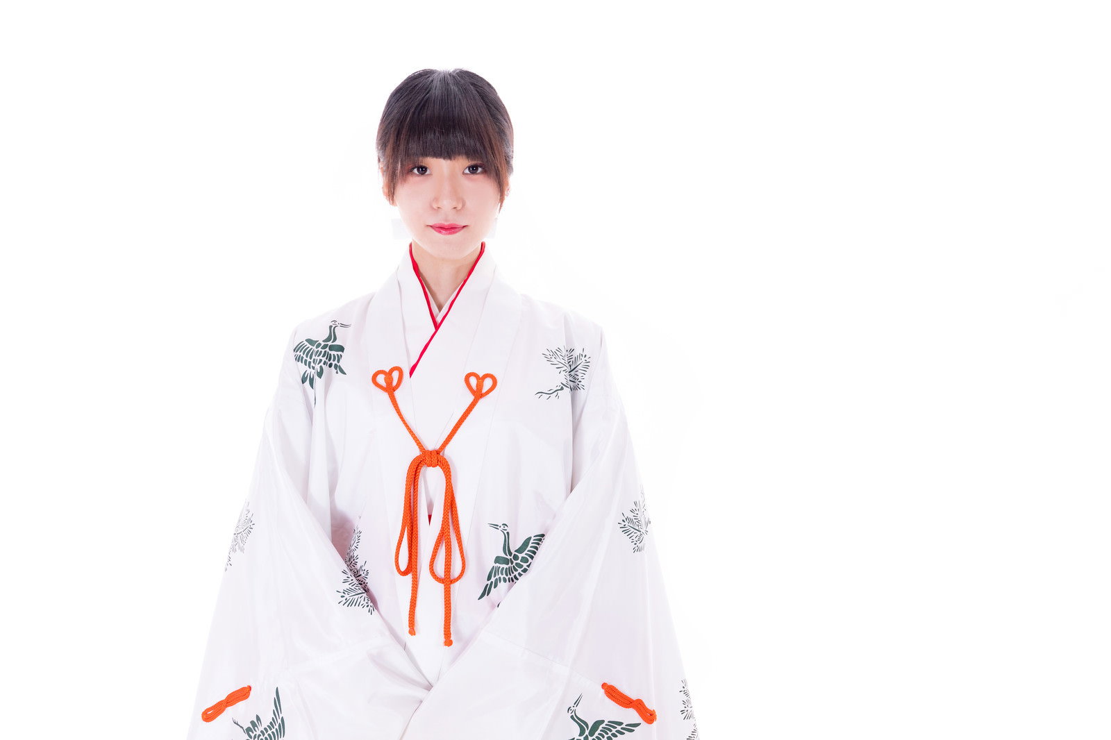 白い装束と赤い袴の巫女装束を身に着けて正座している女性［モデル：緋真煉］