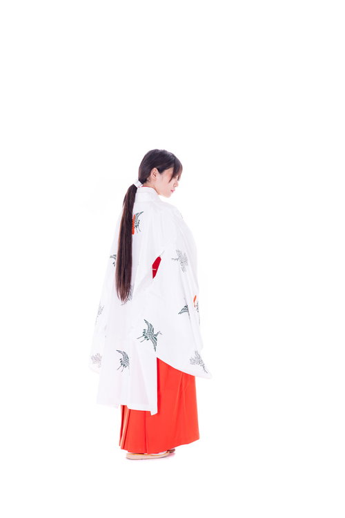 神社で巫女装束を着た女性の後ろ姿