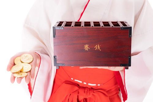 保有するビットコインを賽銭箱に投入する巫女