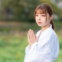 白装束で両手を合わせて祈願する女性の祈りの瞬間の写真