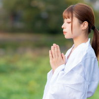 白い巫女装束で両手を合わせて目を閉じてお願いする女性の写真