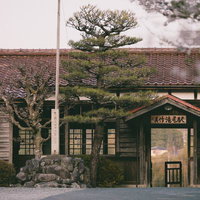 瓦屋根の美作滝尾駅舎、赤茶色の波状瓦と格子窓が特徴の木造駅舎の写真