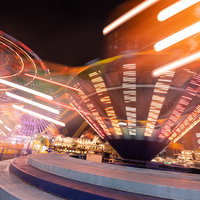 横浜コスモワールドのぐるぐる回るアトラクションが描くオレンジ色の光跡の写真