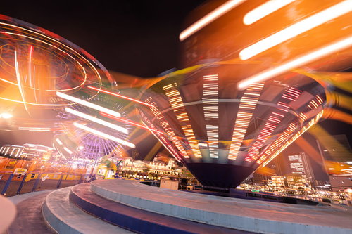 横浜コスモワールドのぐるぐる回るアトラクションが描くオレンジ色の光跡