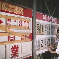 飾磨名店街の案内板を見に来た女性、昭和レトロな商店街の風景の写真