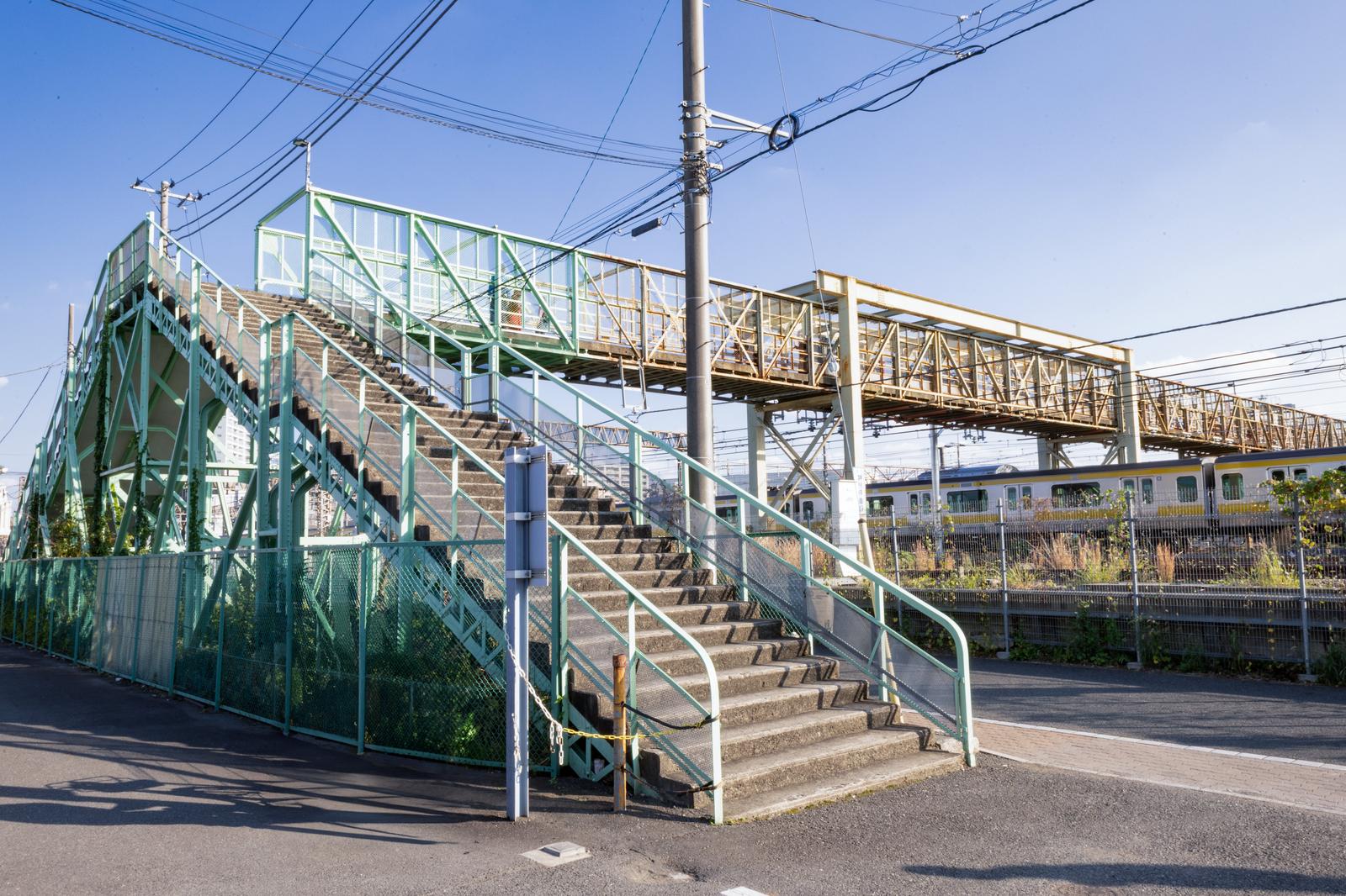 緑色の跨線橋が架かるJR三鷹駅周辺の駅舎と線路