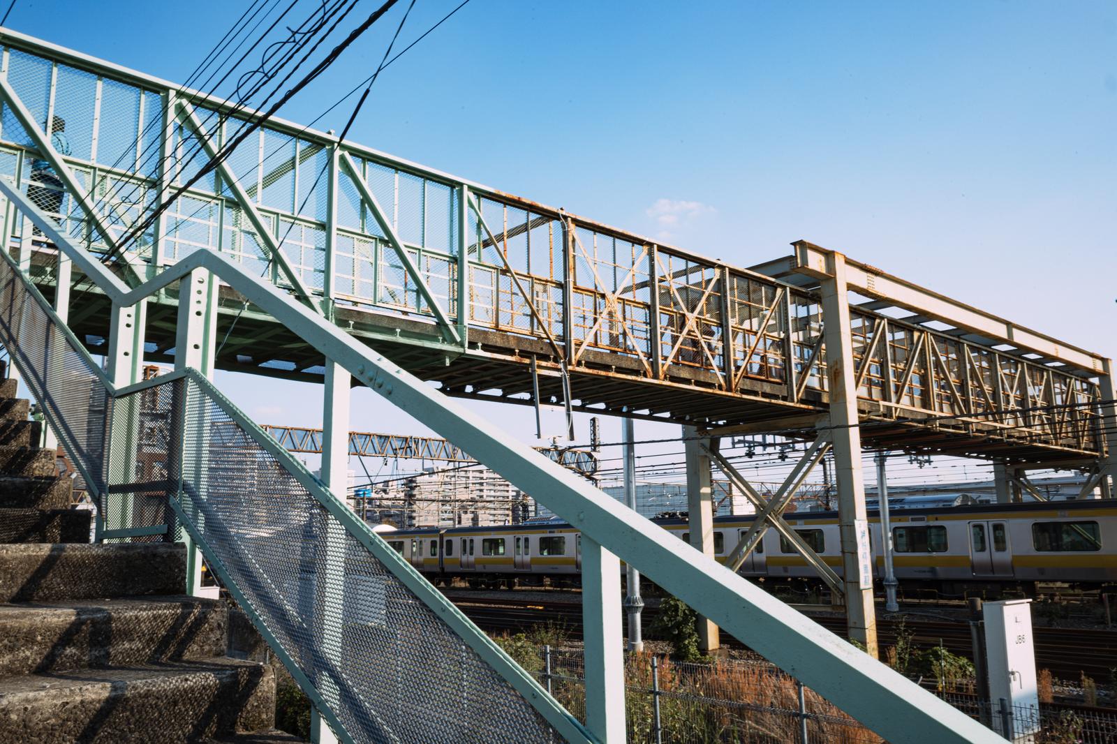 JR三鷹駅の緑色の跨線橋と階段、鉄道施設の写真