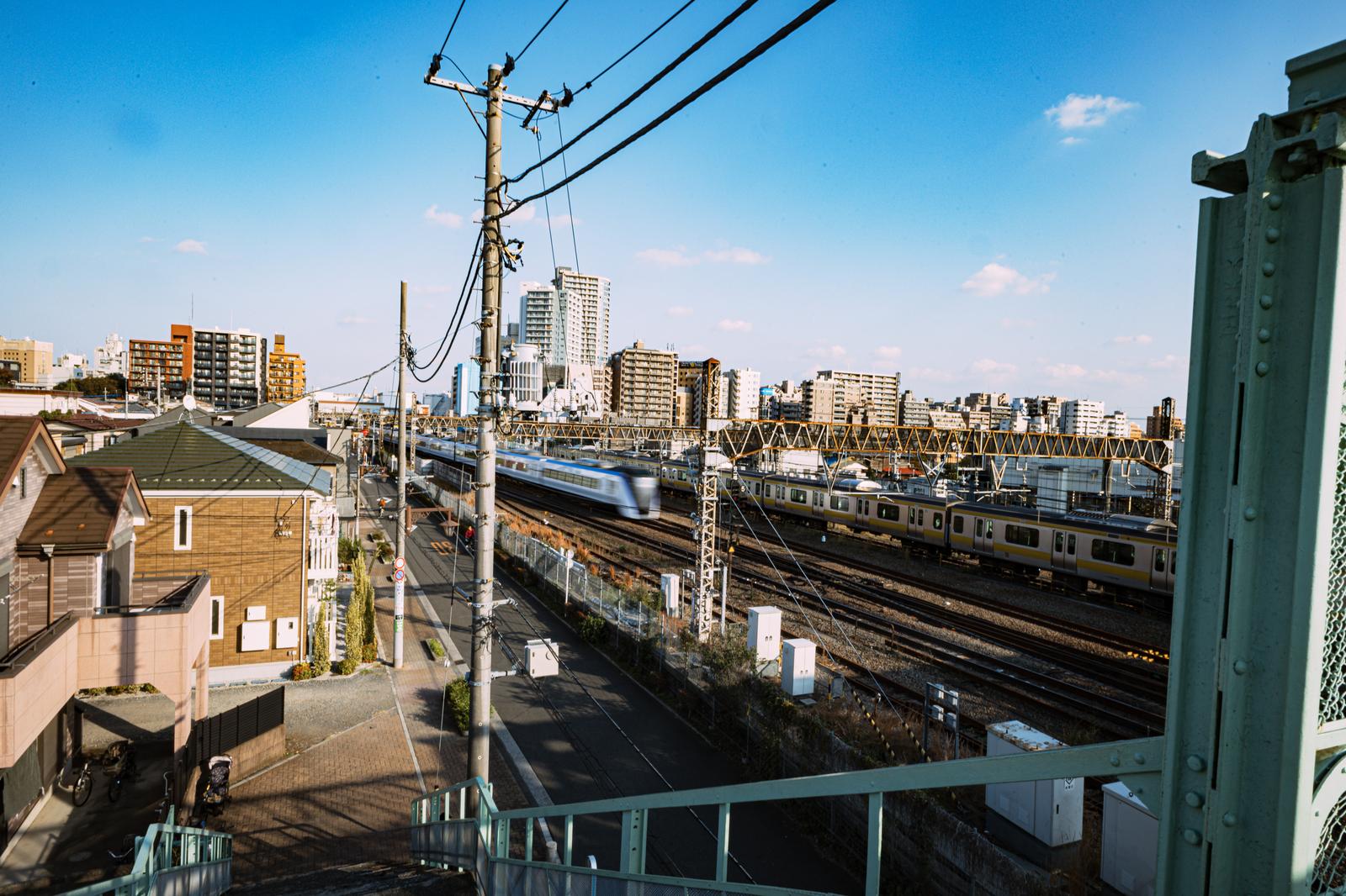 跨線橋から見た三鷹駅の電車と線路、背後に広がる町並み